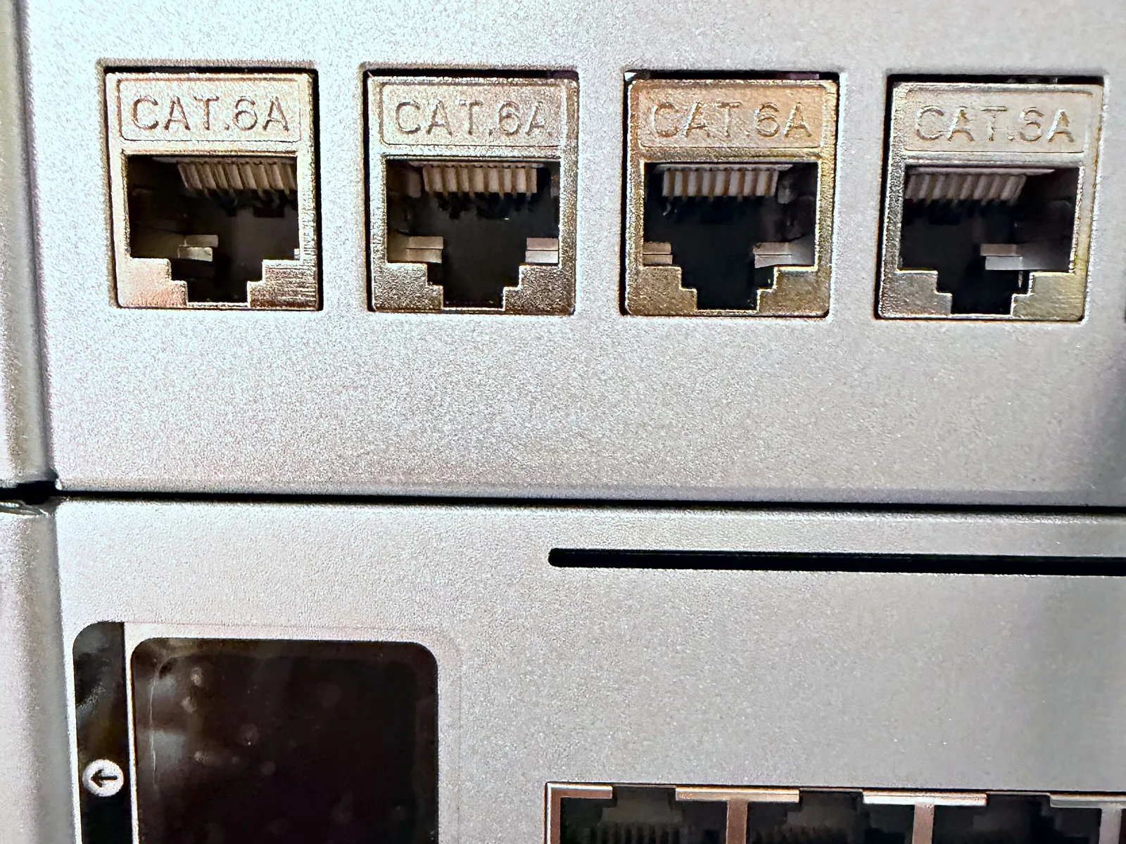 Shielded Cat 6A patch panel ports above a UniFi managed switch