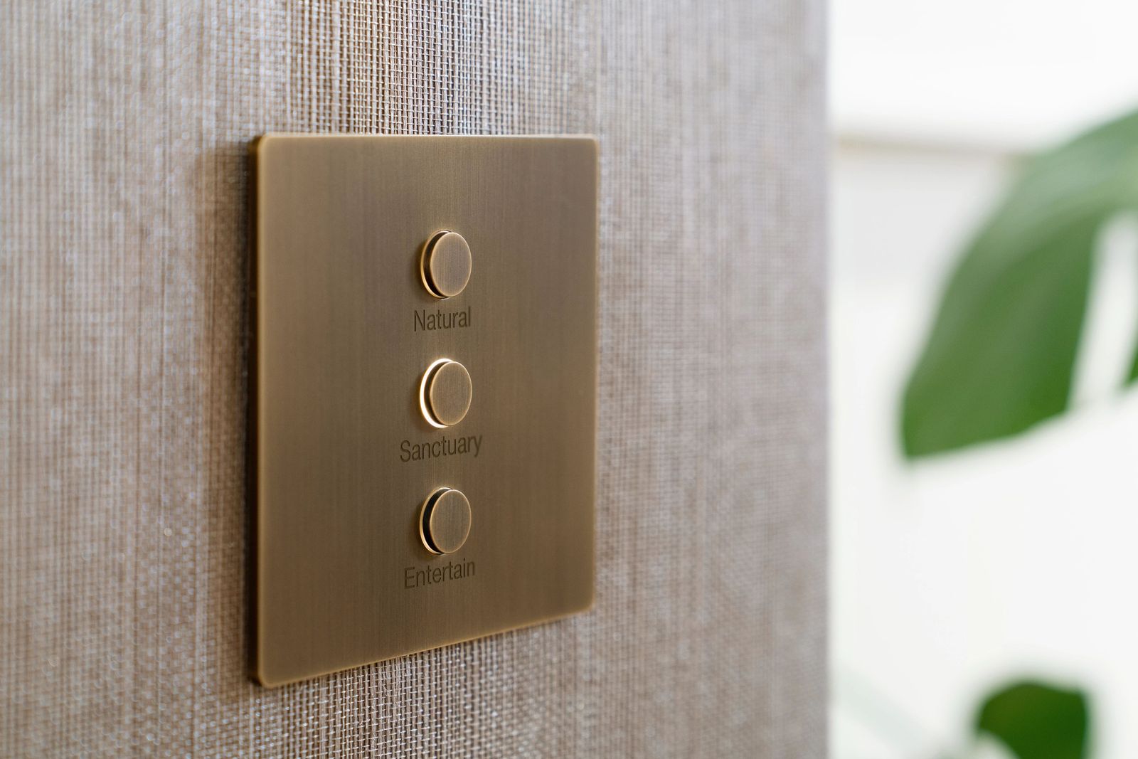 A brass lighting keypad engraved with named scenes