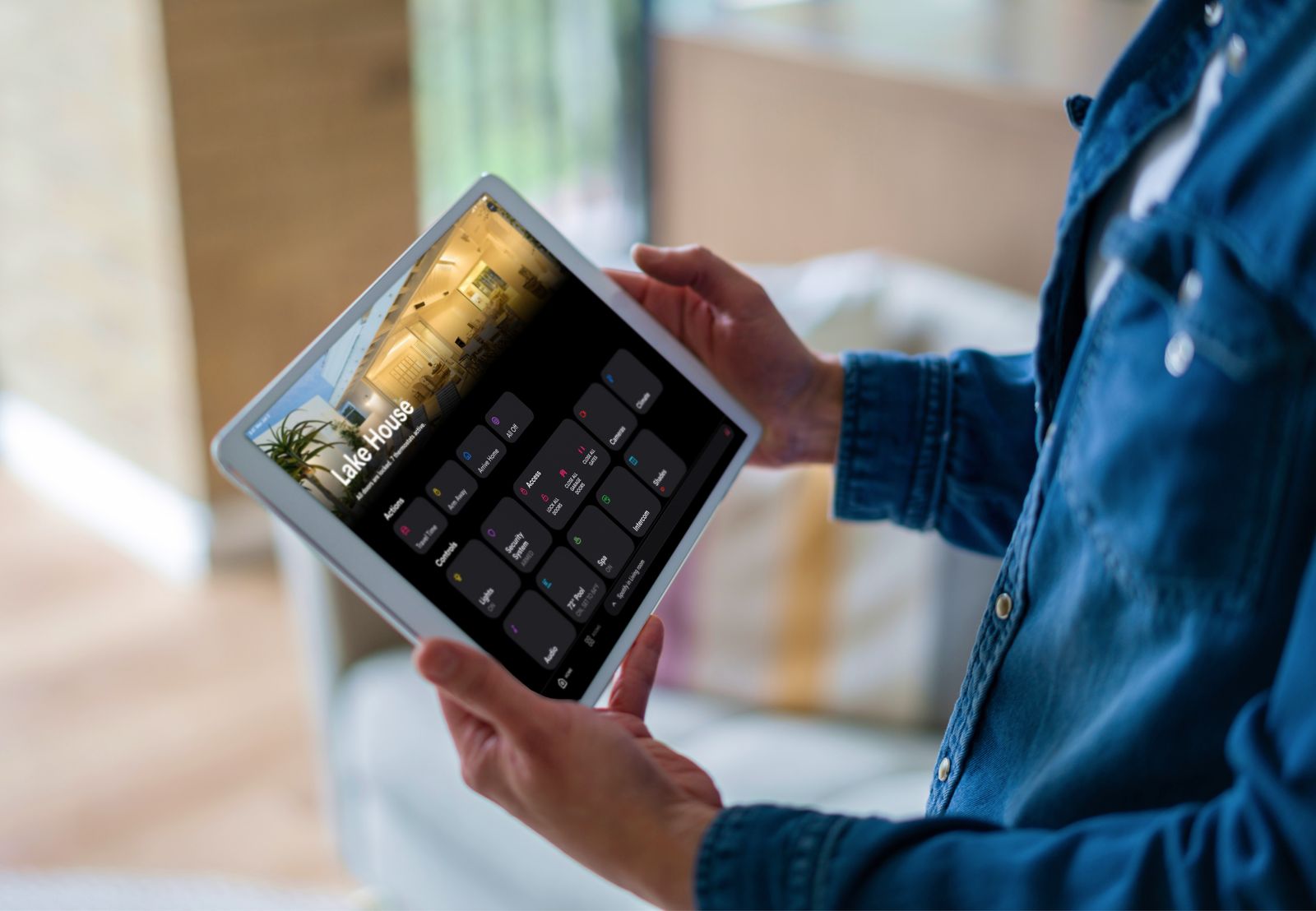 A tablet showing whole-home control: lights, shades, cameras and audio